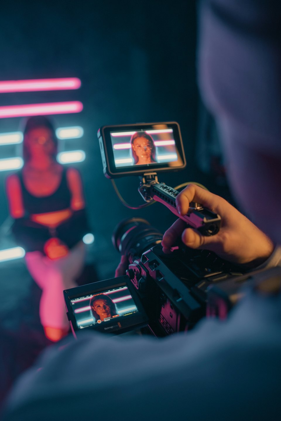 Professional video camera recording a woman in a studio.